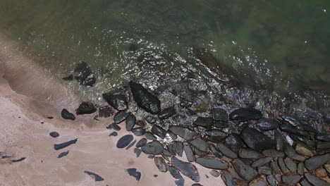 Toma-De-Seguimiento-Vertical-De-Drones-De-La-Costa-De-La-Isla-Con-Rocas-Y-Playa