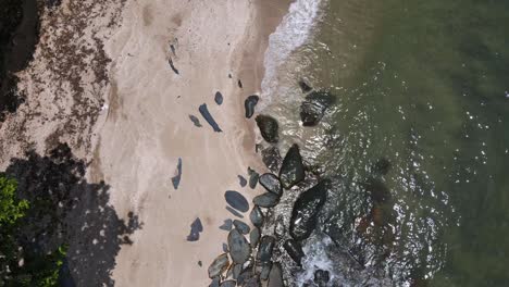 drone-vertical-tracking-shot-of-jungle-beach-and-ocean-with-granite-rocks