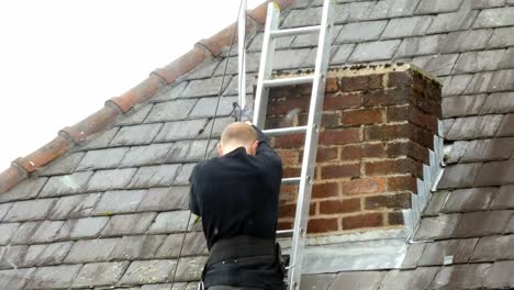 Man-on-ladder-installing-digital-television-aerial-on-home-roof