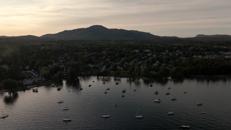 Segelboote-Vertäut-über-Dem-Ruhigen-Strandwasser-Im-Lake-Memphremagog,-Quebec,-Kanada-Bei-Sonnenuntergang---Luftdrohne