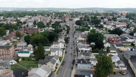 Small-town-America,-USA,-aerial-establishing-shot-of-homes,-businesses,-housing-apartment,-rural-feed-mill,-two-story-colonial-historic-homes,-church,-summer-daytime-scene