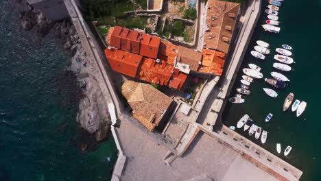 Aerial-top-down-view-out-of-harbour-and-Old-Town-city-walls-of-Dubrovnik,-Croatia-with-mountains-and-sea-in-4k
