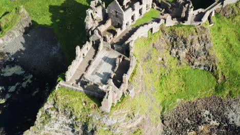 Rotierende-Luftaufnahme-Des-Dunluce-Castle-In-Irland-An-Einem-Sonnigen-Tag