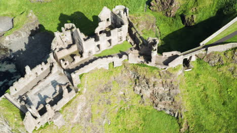 Aerial-pan-left-shot-of-the-now-ruined-Dunluce-Castle,-its-walls-and-halls