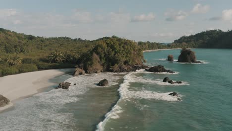 Filmische-Drohnenaufnahme-Der-Wellen,-Die-Am-Strand-Im-Dschungel-Von-Costa-Rica-Zusammenbrechen
