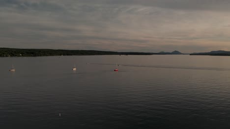 Blick-Auf-Den-Sonnenuntergang-Mit-Kleinen-Booten,-Die-Den-Ruhigen-See-Von-Memphremagog-überqueren,-Der-Zwischen-Magog,-Quebec,-Kanada-Und-Newport,-Vermont,-USA-Liegt-–-Extreme-Weitwinkelaufnahme