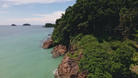 Aerial-tracking-shot-of-tropical-coastline-and-ocean-relieving-three-tropical-Islands-in-Thailand