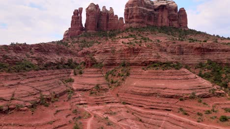 Rising-aerial,-Cathedral-Rock-landscape,-natural-mountain-formation,-Sedona-Arizona-on-a-cloudy-day