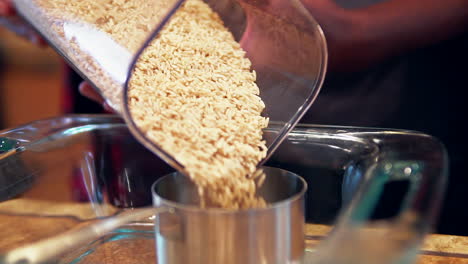 Pouring-whole-grain-brown-rice-into-a-measuring-cup-for-a-homemade-recipe---slow-motion