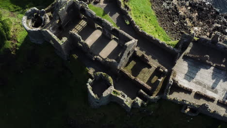 Birdseye-shot-of-the-medieval-Dunluce-Castle-and-a-beautiful-landscape