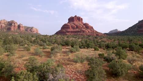 Rising-Aerial,-Bell-Rock-mountain-formation-on-a-clear-morning-with-blue-skies,-Sedona-Arizona