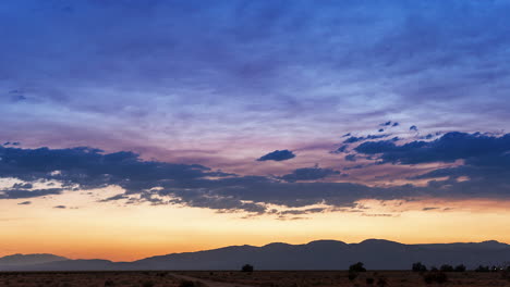 The-suns-sets-in-majestic-splendor-over-the-Mojave-Desert-landscape-and-rugged-mountain-range-in-the-time-lapse
