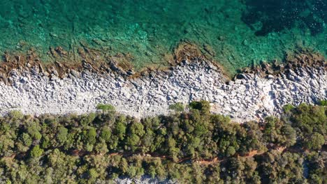 An-aerial-truck-shot-along-the-rocky-coastline-of-Losinj-Island,-Croatia-during-the-day