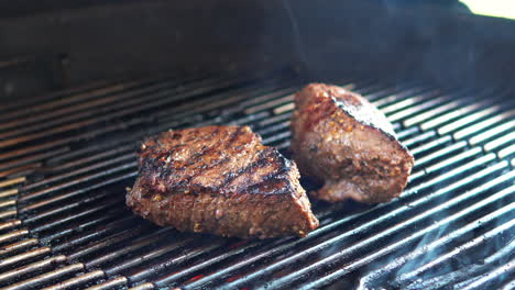 Steaks-on-the-barbecue-grill-cooking-over-glowing-coals---isolated