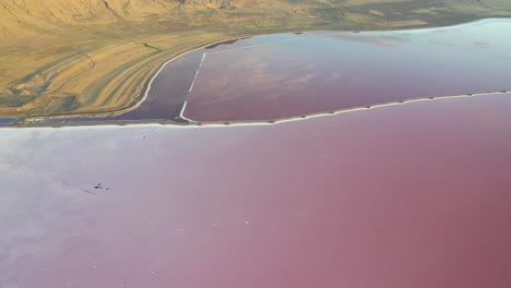 Aerial-View-of-Pink-Lake-Water-Under-Desert-Hills-by-Great-Salt-Lakes,-Utah-USA