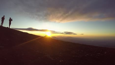 silhouetted-hikers-take-photos-to-celebrate-achievement-of-sunrise-volcano-hike