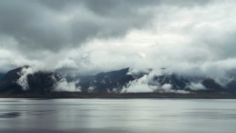 Montaña-Majestuosa-Junto-Al-Lago-Rodeada-De-Nubes-Dramáticas-En-Islandia-En-Un-Clima-Cambiante---Lapso-De-Tiempo