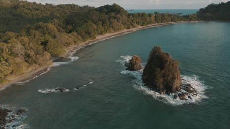 Vista-Aérea-De-Drones-De-Una-Playa-Y-Pilas-De-Mar-En-Un-Parque-Nacional,-Manuel-Antonio,-Quepos,-Costa-Rica