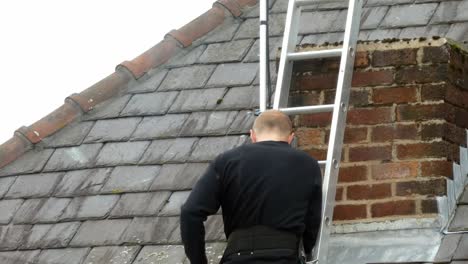 Man-on-ladder-installing-digital-television-aerial-on-home-chimney