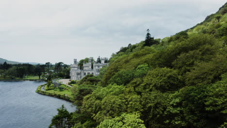 Aerial-dolly-in-shot-of-a-forest-nearby-the-Kylemore-Abbey-in-Ireland