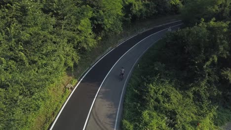 aerial-of-A-Cyclist-on-a-mountain-road,-losing-something-to-stop,-Italy