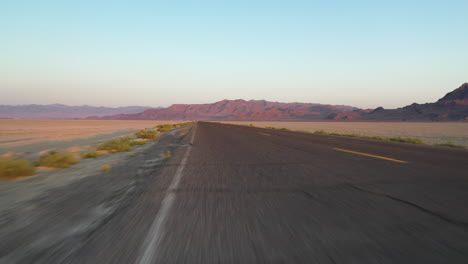 Driving-on-Empty-Road-by-Bonneville-Salt-Flats-and-Speedway-Fileds-in-Utah-USA
