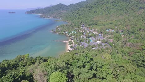 Aerial-shot-of-jungle,-beach,-ocean-and-resort-hotel-on-a-tropical-Island