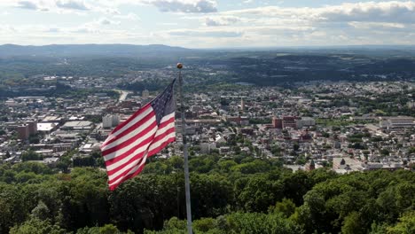 Quintessential-Anytown,-American-city-under-USA-flag,-patriotic-Memorial-Day,-July-4th,-establishing-shot-urban-United-States,-diversity-inclusion-population-growth-theme,-multicultural-Reading-PA