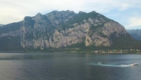 Ein-Schnellboot-Auf-Einem-See-Mit-Einem-Berg-Im-Hintergrund,-Comer-See,-Italien