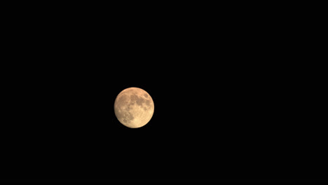 Full-Moon-Illuminated-Orange-In-Dark-Night-Sky,-Astro-Time-Lapse