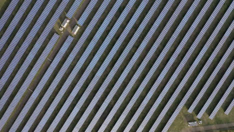 Aerial-view-flying-over-solar-panel-farm-on-a-sunny-day,-the-future-of-green-renewable-energy-is-the-sun