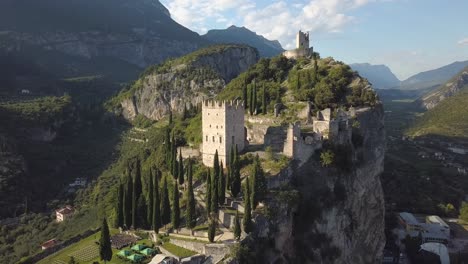 Old-ruins-of-a-fortress-on-top-of-a-mountain-cliff-rock,-Castello-di-Arco,-Riva-del-Garda