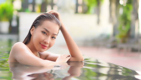 Young-Seductive-Asian-Female-With-Wet-Hair-Posing-to-a-Camera-in-Swimming-Pool