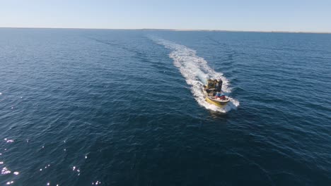 Barco-De-Pescadores-Navegando-En-El-Tranquilo-Mar-Patagónico-Azul-En-Península-Valdés,-Patagonia,-Argentina---Drone-Aéreo