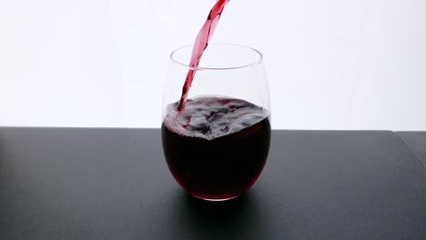Bordeaux-red-wine-poured-into-the-wine-glass-on-white-background
