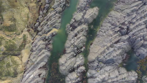 Beautiful-rock-pattern-in-between-small-lakes-of-green-water