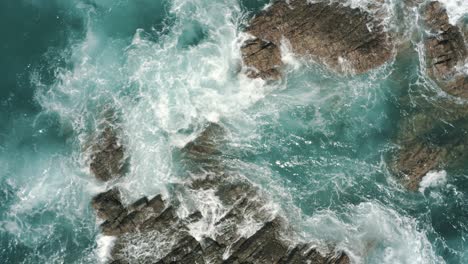 Drohnen-Luftaufnahme-Von-Oben-Auf-Die-Wellen,-Die-Auf-Den-Felsen-Im-Ozean-Von-Costa-Rica-Krachen