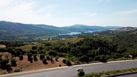 Mountains-highway-traffic-and-Lake-at-Crystal-Spring-Reservoir-aerial-drone-move-forward