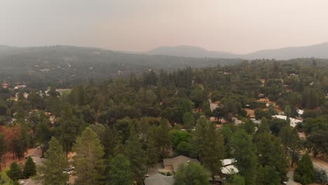 Orbiting-aerial-shot,-smoky-mountain-community,-Creek-Fire,-California