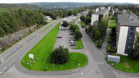 Aerial-view-of-apartment-buildings-a-road-and-forest,-in-a-Swedish-neighborhood---dolly,-drone-shot