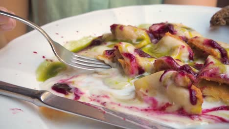 4k-close-up-of-woman-eating-Ravioli-with-colurful-cream-sauce-and-basil