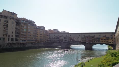4k-Schöne-Aussicht-Auf-Die-Berühmte-Ponte-Vecchio-Am-Fluss-Arno-Mit-Einem-Gondelboot-Bei-Sonnenuntergang