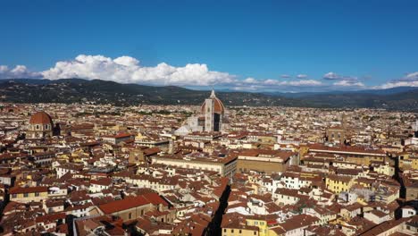 Drone-flying-fast-to-Cathedral-of-Santa-Maria-del-Fiore-and-over-city-on-a-sunny-day-in-Florence-in-Italy-in-4k