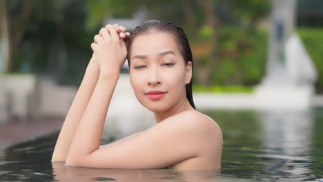 Asiatische-Frauenschönheit,-Die-In-Einer-Poolnahaufnahme-Aufwirft