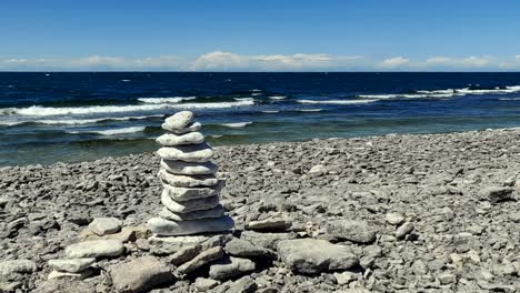 Pile-of-rocks,-on-the-coast-of-Gotland,-waves-in-the-background,-on-a-windy,-summer-day,-in-Sweden---static-view