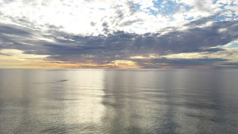 AERIAL:-Locked-Shot-of-Baltic-Sea-During-Golden-Hour-with-Majestic-Horizon-with-Orange-and-Blue-Colours-in-the-Sky