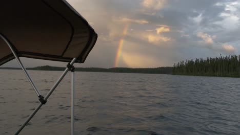 Wunderschöner-Regenbogen,-Der-Durch-Den-Bewölkten-Himmel-Erscheint,-Von-Einem-Fischerboot-Auf-Einem-See-Aus-Gesehen
