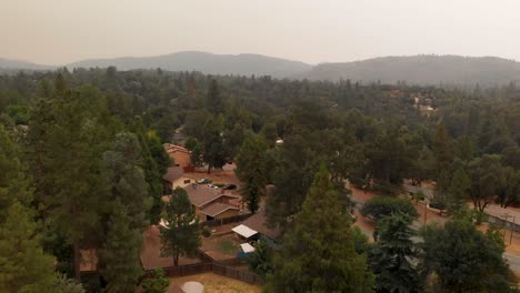 Aerial-shot-over-community,-orange-smoke-filled-sky-from-Creek-Fire,-California