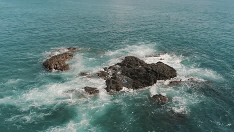 Drone-aerial-rotating-and-waves-crashing-on-the-rocks-in-the-ocean-of-Costa-rica