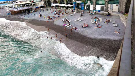 Gente-Jugando-En-La-Playa-Con-Una-Pelota-Al-Atardecer-En-Amalfi,-Italia